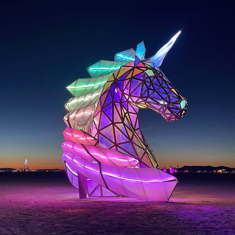 Lit up unicorn sculpture against the night sky