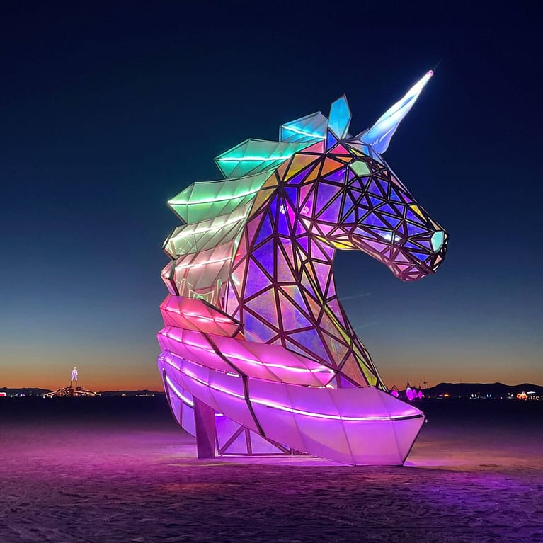 Lit up unicorn sculpture against the night sky
