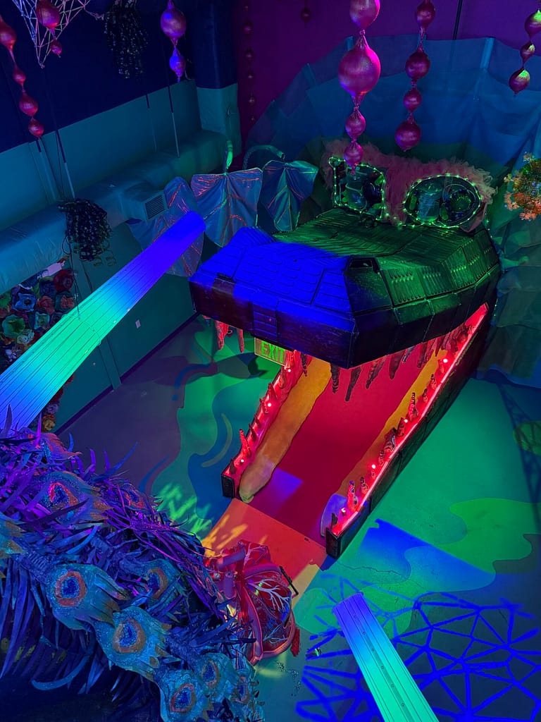 Alligator tunnel art installation with multiple colored spotlights