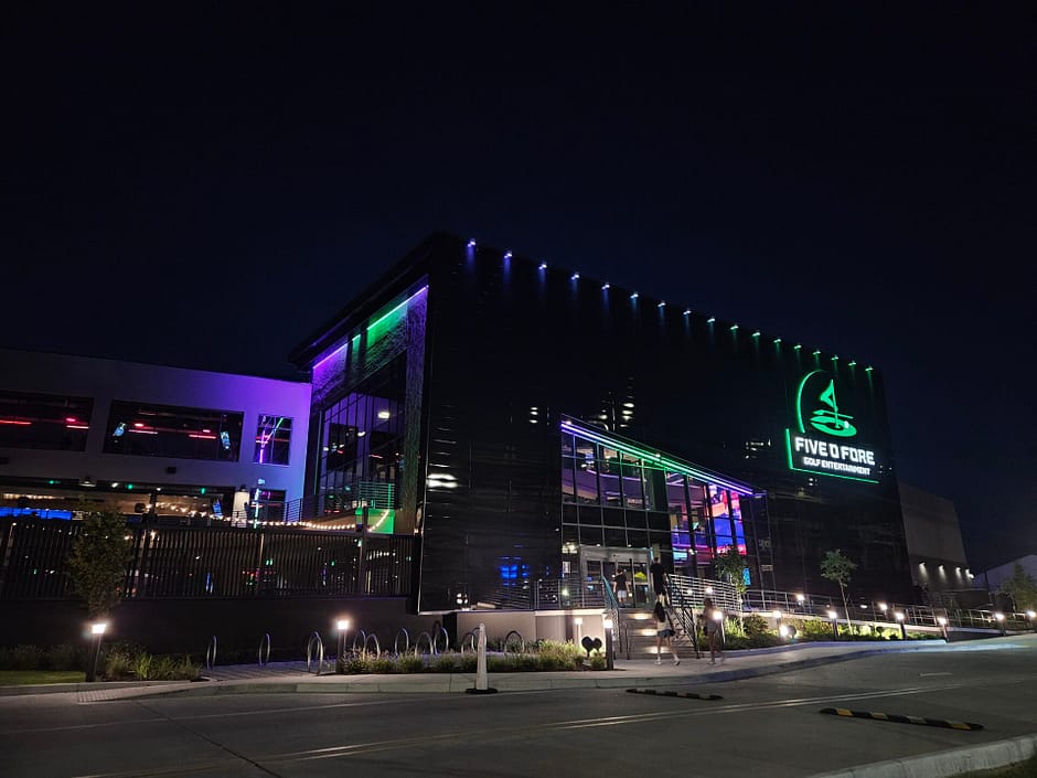 Five O Fore Golf Entertainment Building exterior with purple and green lighting shot from across the street