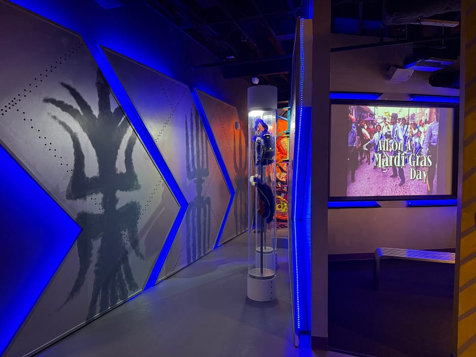Hallway with blue lighting and a TV screen playing a movie about Mardi Gras